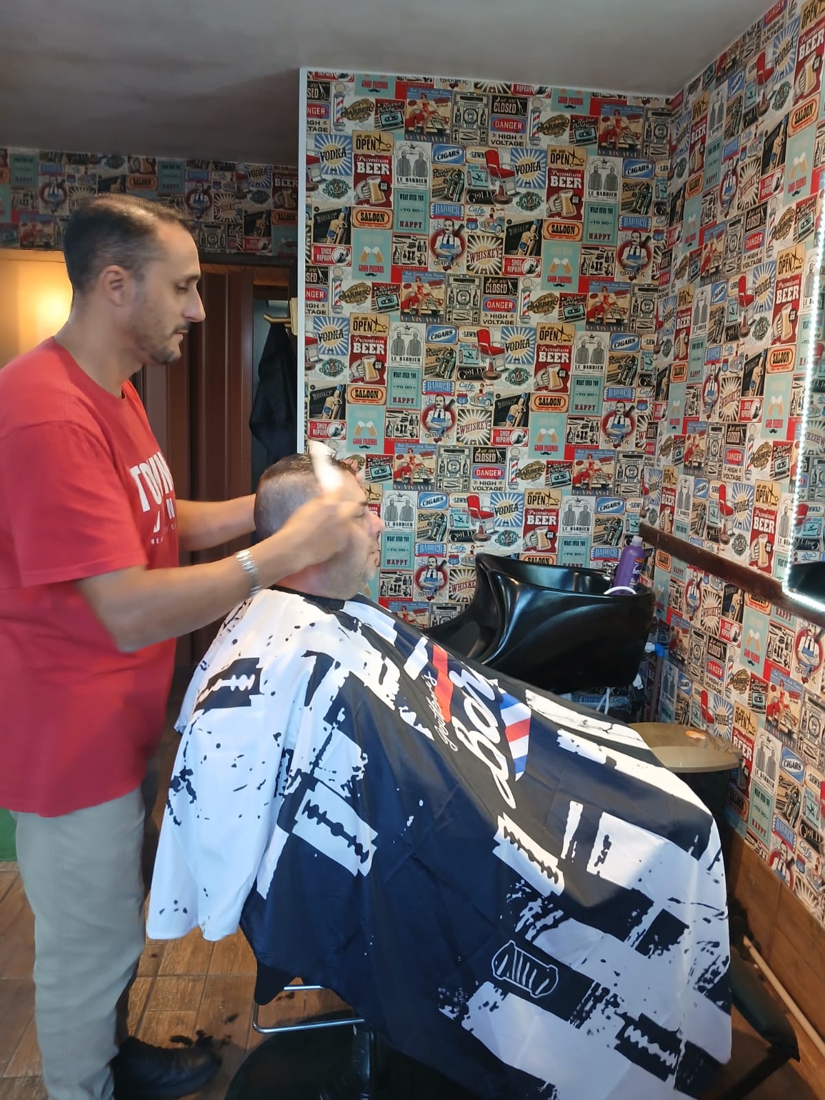 Barbeiro realizando corte de cabelo com tesoura.